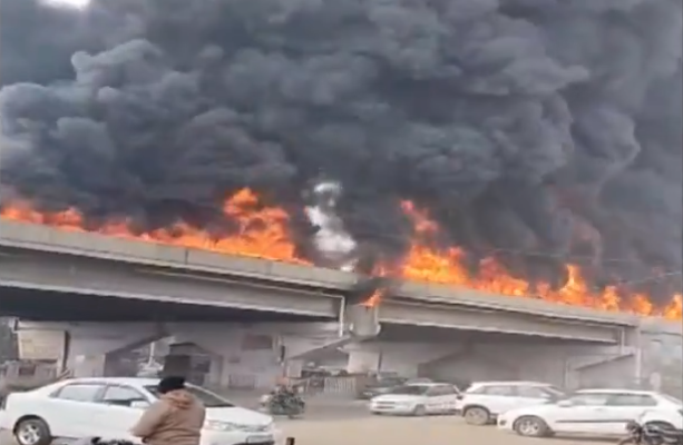 Smokes and flames billow out of a flyover after a massive fire broke out in an oil tanker as it hit a divider and overturned, at Khanna in Ludhiana on Wednesday. (ANI Photo) (ANI)
